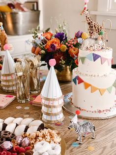 a table topped with cakes and desserts on top of a wooden table covered in confetti