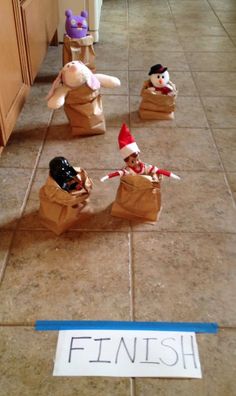 three stuffed animals sitting in bags on the floor next to a sign that says finish