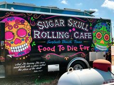 a food truck parked on the side of the road with sugar skull rolling cafe painted on it's side