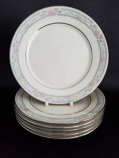 six plates stacked on top of each other with floral designs and scrolls around the edges