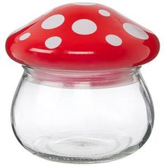 a red and white mushroom shaped jar with polka dots on the lid, sitting in front of a white background