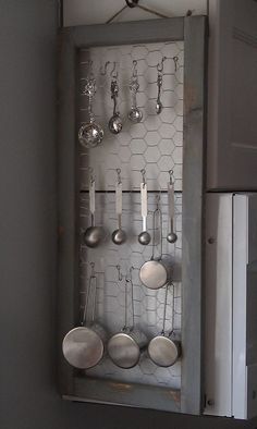 an old kitchen cabinet with pots and pans hanging on it's side wall