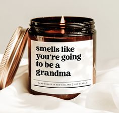 a candle with a label on it sitting next to a container that says smells like you're going to be a grandma