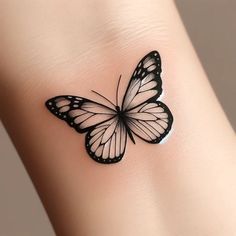 a black and white butterfly tattoo on the side of a woman's arm,