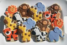 decorated cookies in the shape of animals and giraffes on a white plate