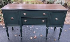 an old dresser painted green with gold hardware