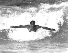 a man riding a wave on top of a surfboard in the middle of the ocean