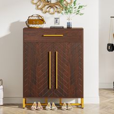 a wooden cabinet with gold handles and two pairs of shoes on the bottom shelf next to it