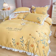 a bed with yellow comforters and pillows on it