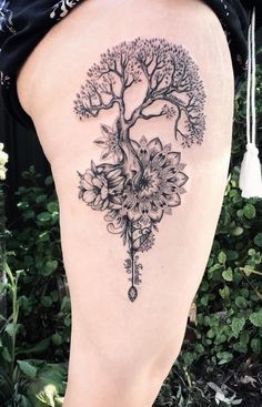 a woman's thigh with a tree tattoo on it