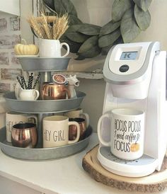 two coffee mugs are stacked on top of each other in front of a wreath