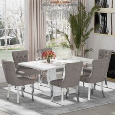 a dining room table with chairs and a chandelier