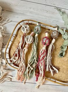 some tassels are laying on a wicker tray next to plants and beads