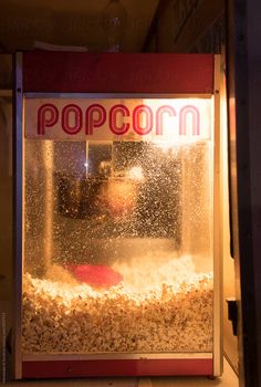 a popcorn machine sitting on top of a counter next to a window filled with popcorn