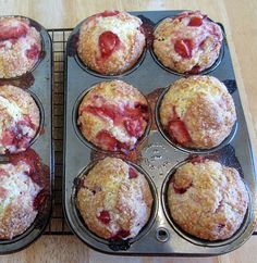 several muffins with strawberries in them on a tray