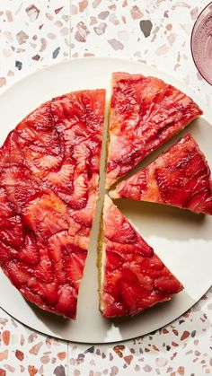 a strawberry upside down cake on a plate with one slice cut out and the other half eaten