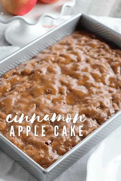 an apple cake in a pan on a table next to apples and a plate with the words cinnamon apple cake