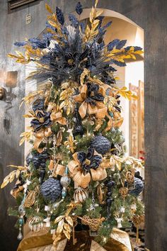 a blue and gold christmas tree with decorations