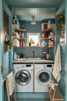 Small laundry room with blue walls, a washer and dryer, shelves stocked with cleaning supplies and towels, a plant by a small window, and a drying rack. Flooring Options Durable, Pet Washing Station, Ironing Station, Magnetic Paint, Wall Mounted Drying Rack, Compact Laundry, Stylish Laundry Room, Boho Inspo