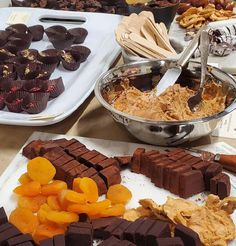 chocolates, orange slices and other dessert items are on display at a buffet table