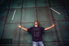 a man standing in front of a wall with his arms spread out and two sticks sticking out