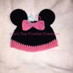 a crocheted minnie mouse hat with a pink bow on the front and black ears