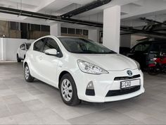 a white car parked in a garage next to other cars