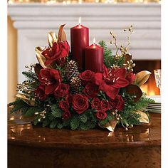 a christmas centerpiece with candles and flowers