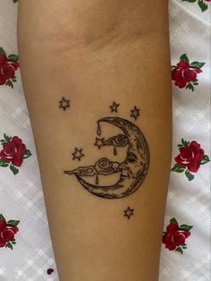 a woman's leg with a tattoo on it that has a crescent moon and stars