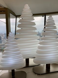 several white plates stacked on top of each other in front of a large glass window