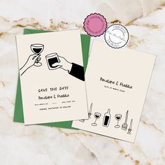 wedding save the date cards with wine glasses and bottle on marble slaby countertop