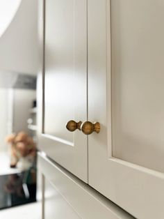 a close up view of the handles and knobs on a white kitchen cabinet door