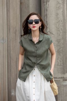 Elevate your everyday style with our military green short-sleeve linen blouse. Crafted from high-quality linen fabric, this blouse offers a comfortable and breathable fit. The military green color exudes a sense of versatility and pairs well with both neutral and bold colors. The short sleeves provide a relaxed and laid-back look, perfect for casual occasions. The button-up front adds a touch of sophistication, making it suitable for office settings as well. Embrace the effortlessly chic vibe of Short Sleeve Khaki Shirt With Buttons, Khaki Short Sleeve Shirt With Buttons, Green Short Sleeve Blouse With Button Closure, Olive Tops For Summer Workwear, Khaki Solid Color Summer Blouse, Khaki Short Sleeve Shirt, Green Short Sleeve Blouse With Buttons, Olive Button-up Summer Top, Olive Button-up Top For Summer