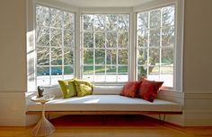 a white couch sitting in front of a window with lots of windows on top of it