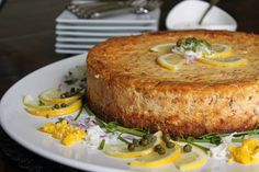 a cake on a plate with lemons and herbs