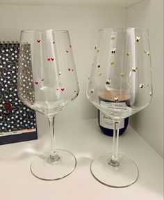 two wine glasses sitting next to each other on a counter