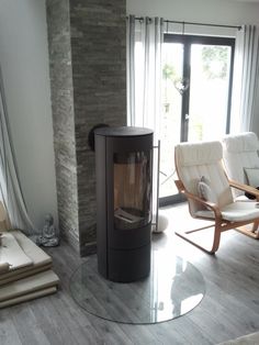 a living room with two chairs and a wood burning stove in it's center