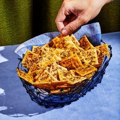 a basket filled with crackers sitting on top of a blue cloth covered tablecloth