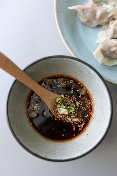 two bowls filled with food and a wooden spoon