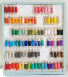 the wall is filled with many different colored thread spools