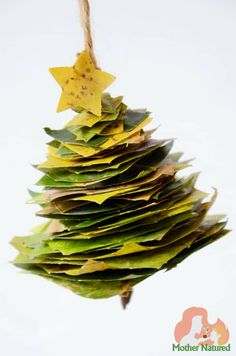 a christmas tree made out of leaves hanging from a rope with star decorations on it