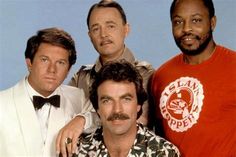 three men are posing for the camera with one man wearing a red shirt and bow tie