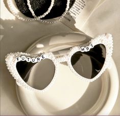 two heart shaped sunglasses with the words future mrs and mr on them sitting on a plate