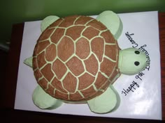 a cake shaped like a turtle on top of a white sheet paper with writing on it