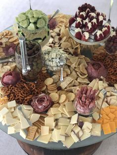 an assortment of cheeses, crackers and meats arranged on a round table