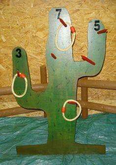 a green cactus shaped clock sitting on top of a wooden table next to a wall