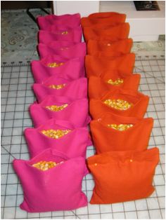 several bags are lined up on the floor and one is pink, orange, and yellow