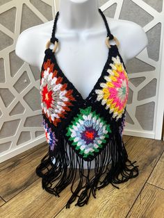 Granny square halter top with multicolored accents. Tie on neck and back can be altered to preference. Wooden rings on straps. Size XL Multicolor Halter Neck Crop Top, Multicolor Triangle Halter Top For Party, Summer Multicolor Triangle Halter Top, Black Bohemian Halter Top For Party, Multicolor Halter Neck Crop Top For Beach, Bohemian Black Halter Top For Festivals, Bohemian Triangle Top Halter For Party, Multicolor Summer Halter Top For Festival, Black Bohemian Halter Top