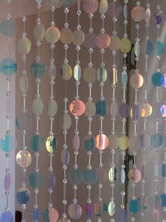 a close up of a curtain made out of circles and beads hanging from it's side