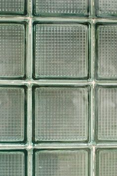 several glass squares are arranged in a gridded pattern on the outside of a wall